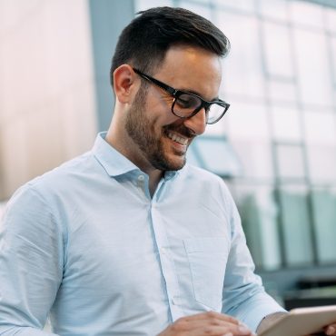 demo-attachment-317-portrait-of-businessman-in-glasses-holding-tablet-AWVHCJU